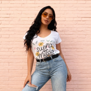 **Descripción del Producto:** Descubre nuestra blusa "Sueña Sin Miedo", una prenda perfecta para expresar tu estilo y actitud positiva. Confeccionada en algodón suave y ligero, esta blusa de corte clásico presenta un atractivo escote en V y mangas cortas, ideal para cualquier ocasión. Su diseño vibrante incluye un estampado colorido de flores que acompaña la inspiradora frase, creando un look fresco y lleno de energía. Combínala fácilmente con jeans o faldas para un acabado casual y chic. ¡Anímate a lucirla y lleva contigo un mensaje motivador todos los días!