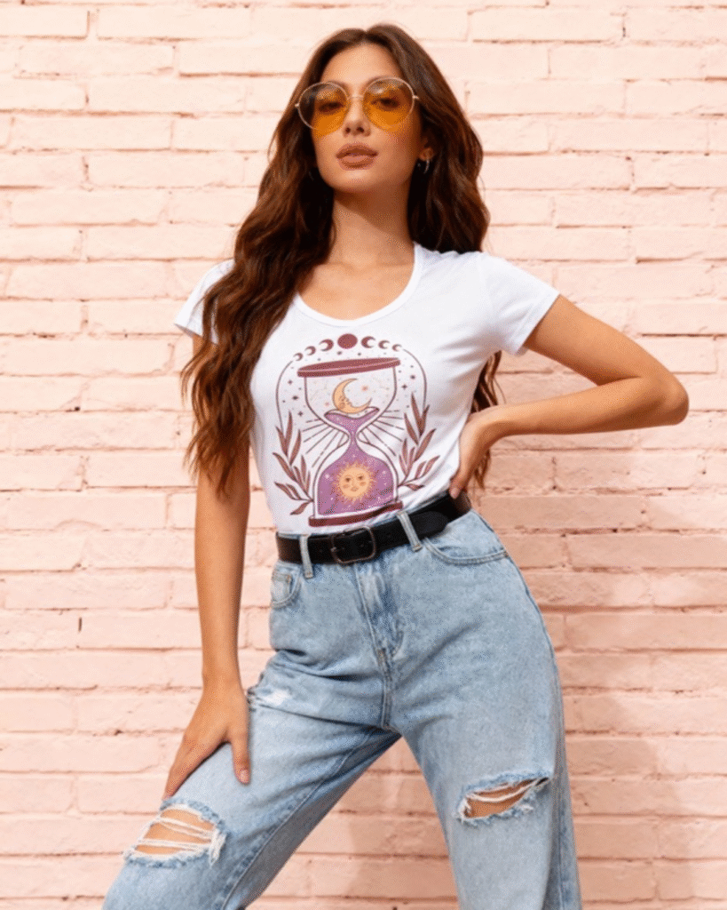 **Descripción del Producto:** Descubre nuestra blusa de algodón blanco con un diseño vibrante y único. Con un corte moderno y cómodo, esta prenda es perfecta para cualquier ocasión. La blusa presenta una ilustración artística que combina elementos de la luna y el sol, rodeada de delicadas hojas, lo que le da un toque bohemio y contemporáneo. Su tejido suave y transpirable asegura que te sientas fresca y cómoda durante todo el día. Combínala con tus jeans favoritos o una falda para un look casual y chic. ¡Hazla parte de tu guardarropa y destaca con estilo!