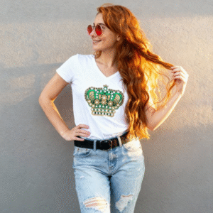 **Descripción del Producto:** Dale un toque de sofisticación a tu atuendo con esta blusa blanca, que presenta un elegante diseño decorado con brillantes en forma de corona en tonos verdes y dorados. Su corte clásico con cuello en V realza la figura, mientras que el tejido suave y transpirable garantiza comodidad durante todo el día. Perfecta para combinar con jeans o faldas, esta blusa es ideal tanto para ocasiones informales como eventos especiales. Añade un toque de glamour a tu guardarropa y siéntete como la reina que eres.